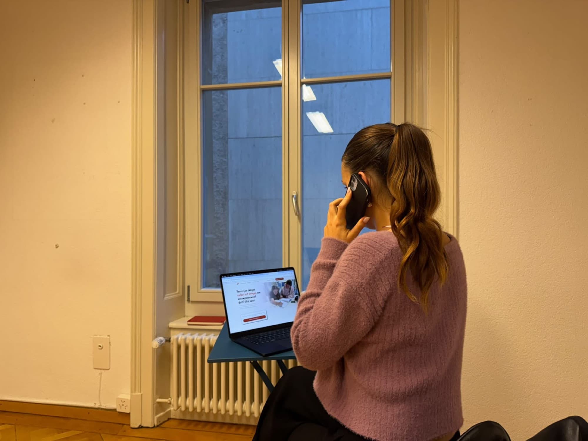 Une conseillère au téléphone devant son ordinateur portable, qui affiche le site d’Arpana, dans un bureau lumineux.