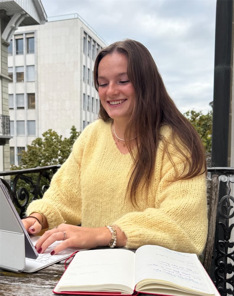 Louise, souriante, à sa table de travail.